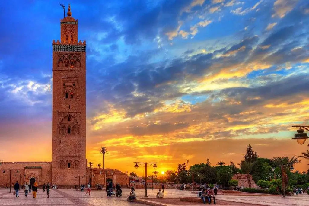 Koutoubia Mosque rising over Jemaa el-Fnaa square at sunset in Marrakech, Morocco.